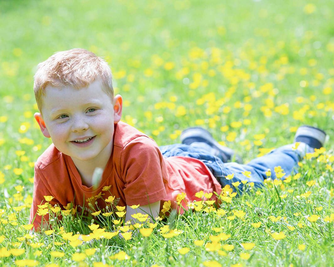 portrait photo of a young boy in a meadow