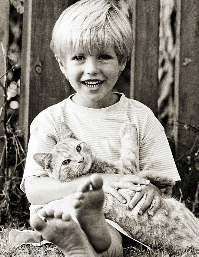 monochrome photo of boy holding a cat