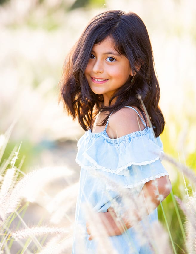 young girl standing in long grass